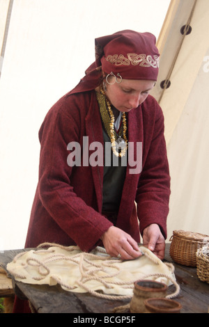 Presentazione di una vecchia dimenticata artigiano di professioni. Una donna in abito tradizionale rendendo un tamburo. Ogrodzieniec, Polonia. Foto Stock