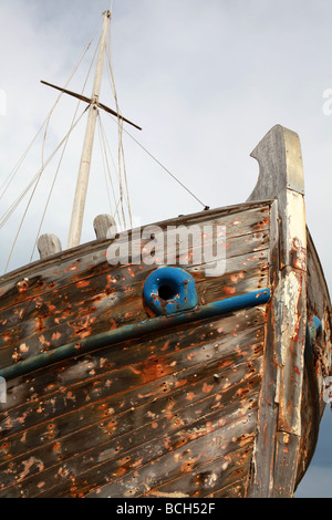 La vernice spogliato dei resti di una grande nave di legno rot contro un cielo nuvoloso Foto Stock