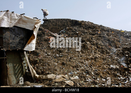 Un uomo è alla ricerca di materiali pregiati in una discarica di rifiuti in Dharavi baraccopoli sono in Mumbai (Bombay) in India. Foto Stock