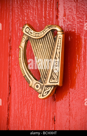 Arpa irlandese porta respingente su un cottage rosso porta Foto Stock