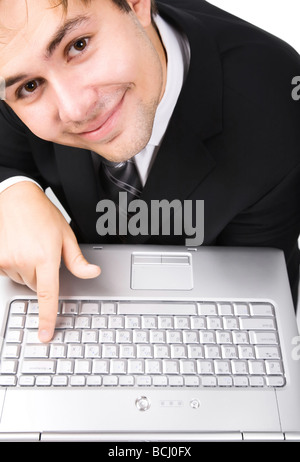 Imprenditore sorridente premendo il pulsante sulla tastiera del notebook Foto Stock