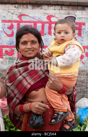 Kathmandu, Nepal. Micro-prestito di credito beneficiario pone nel mercato con suo figlio. Foto Stock