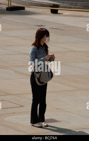 Ragazza asiatica turista che indossa una maschera protettiva per prevenire Covid Coronavirus in trafalgar Square Londra Foto Stock