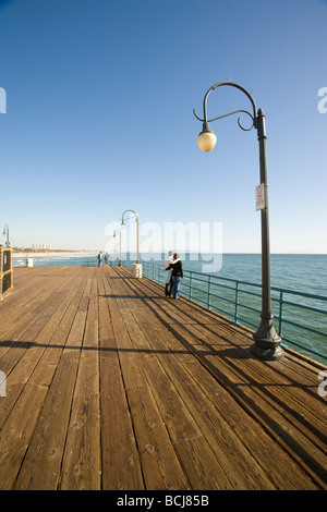 Maschio e femmina giovane in piedi alla ringhiera cercando in vista dell'oceano da Santa Monica Pier a Santa Monica, California, Stati Uniti d'America Foto Stock