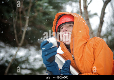 Femmina ice climber gode di una bevanda calda durante una giornata di arrampicata su ghiaccio nella valle di Portage, Alaska Foto Stock