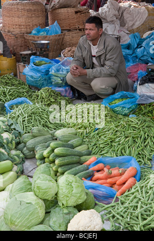 Kathmandu, Nepal. Vicinato mercato ortofrutticolo. Maschio venditore vegetali attende i clienti. Foto Stock