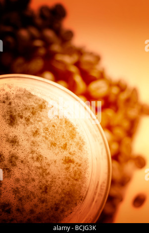 Latte Macchiato in vetro sulla costa di caffè in grani Foto Stock