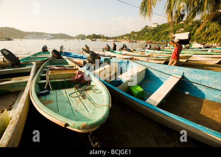 Zihuatanejo Messico pescatore locale preparare barche sulle rive della baia di Zihuatanejo Commercial in nave da crociera ancorata nella baia Foto Stock