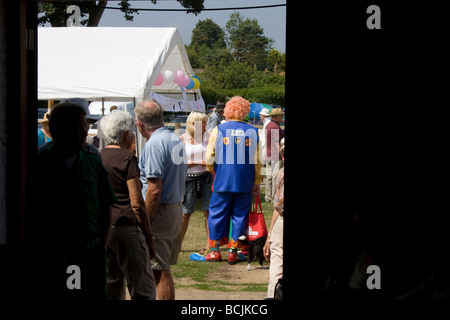 Clown in un giardino fete visto attraverso una porta Foto Stock