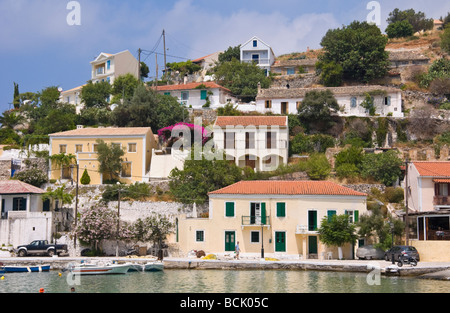 Vista sul porto guardando verso le case vacanza e appartamenti in villaggio di Assos sull'isola greca di Cefalonia Grecia GR Foto Stock