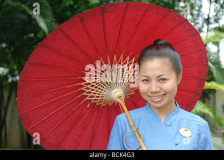 Il Mandarin Oriental Dhara Dhevi, Chiang Mai un hotel 5 stelle di lusso hotel Thai lady con ombrellone ombrellone ombrellone Accoglienza sorridente Foto Stock