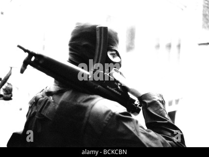 Attentati che indossa una maschera da sci e tenendo a pistola Foto stock -  Alamy