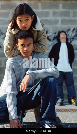 Scena urbana, i giovani di fronte a muro con graffiti Foto Stock