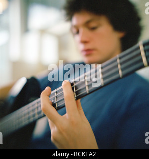 Giovane uomo a suonare la chitarra Foto Stock