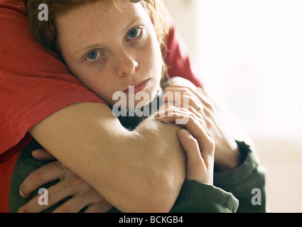 Giovane donna con uomo di braccia attorno a lei Foto Stock