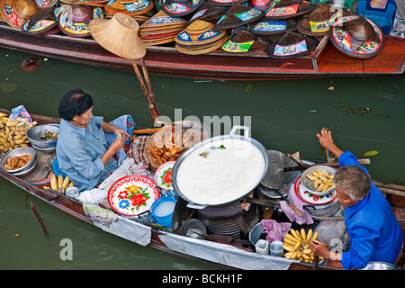 Thailandia. Un venditore di cibo presso il trafficato mercato galleggiante di Damnern Saduak, 80 km a sud-ovest di Bangkok. Foto Stock