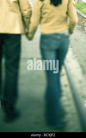 Giovane camminare tenendo le mani sul marciapiede, parte inferiore Foto Stock