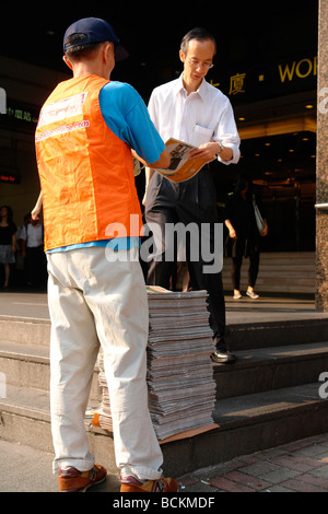 Cina Hong Kong giornale gratuito distribuzione nel quartiere centrale per i pendolari Foto Stock