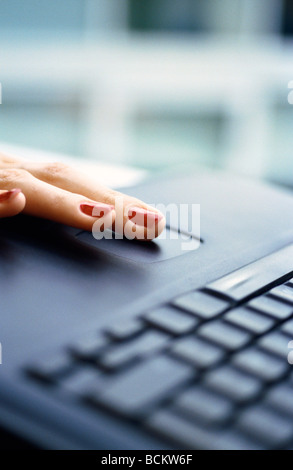 Donna di dito sul computer portatile, close-up Foto Stock