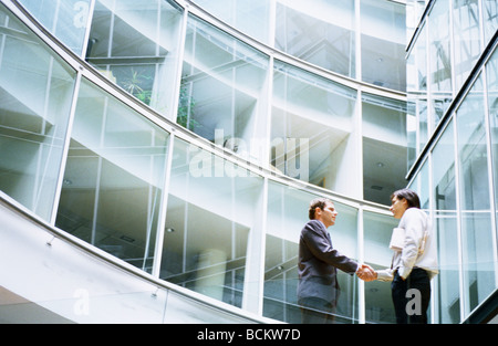 Due imprenditori incontro nella lobby per ufficio a basso angolo di visione Foto Stock