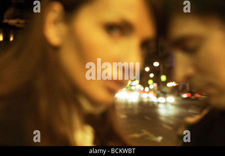 Coppia giovane in strada di notte, offuscata Foto Stock