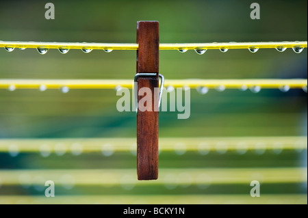 Vestiti di legno peg su un lavaggio wet linea con gocce d'acqua Foto Stock