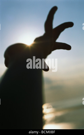 Silhouette di persona il raggiungimento Foto Stock