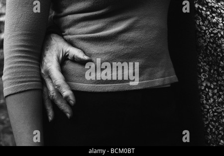 Donna anziana la mano sul più giovane donna l'anca, close-up di metà sezione Foto Stock