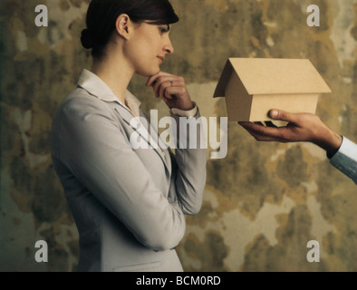 L'uomo tenendo fuori birdhouse per donna, vista ritagliata Foto Stock