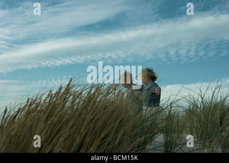 Un ragazzo e una ragazza che corre attraverso le dune erba Foto Stock