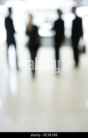 La gente di affari in piedi nella lobby, a piena lunghezza e sfocato Foto Stock