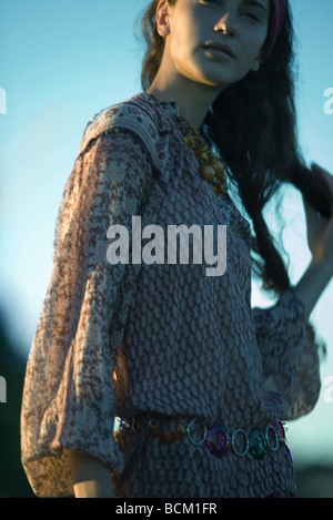 Giovane donna con le mani nei capelli, indossando vestiti hippy, close-up, ritagliato Foto Stock