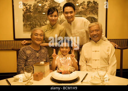 Tre generazioni la famiglia durante la festa di compleanno, sorridente alla fotocamera, ritratto di gruppo Foto Stock
