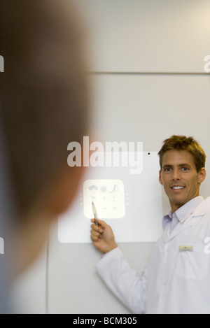 Medico paziente dando prova di visione, la messa a fuoco sullo sfondo Foto Stock