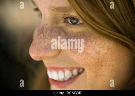 Giovane donna con lentiggini sorridente, profilo Foto Stock