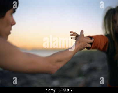 Giovane uomo e donna per raggiungere ogni altro le mani, ritagliato Foto Stock