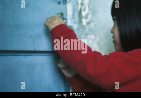 Bambina di apertura della porta laterale Foto Stock