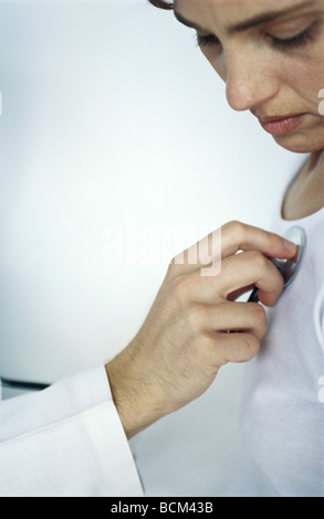 Medico utilizzando uno stetoscopio sulla donna, vista ritagliata Foto Stock