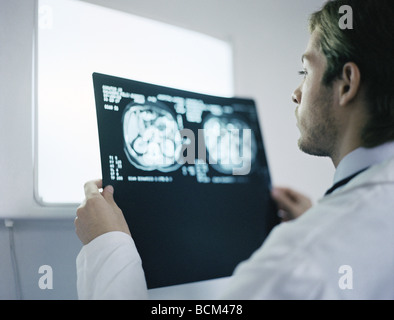 Medico azienda e esaminando le scansioni MRI Foto Stock