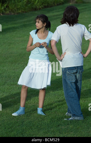 Coppia giovane in piedi nel parco, in attesa Foto Stock