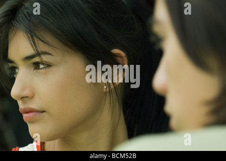 Giovane donna che guarda lontano, teen boy in primo piano, vista ritagliata Foto Stock