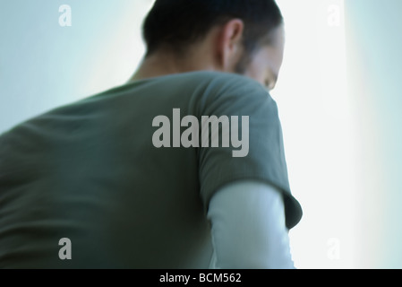 Uomo che guarda lontano, vista posteriore Foto Stock