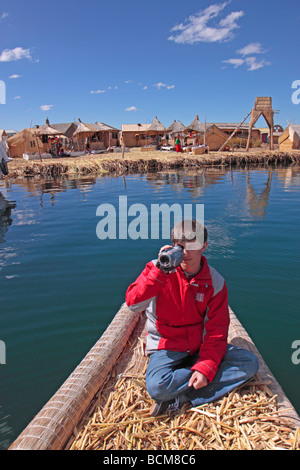 Ragazzo su una barca di reed, Uro Island, il lago Titicaca, Puno, Perù Foto Stock