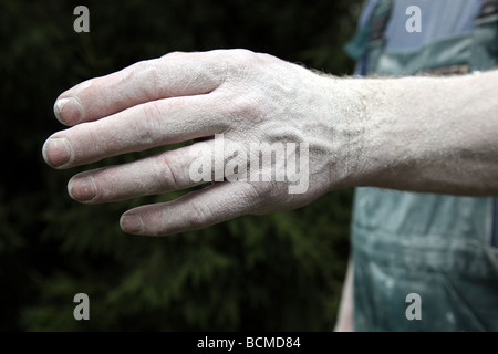 Operai mano coperti di polvere dopo intonacatura di una parete Foto Stock