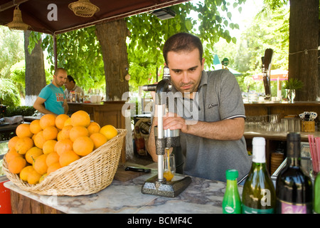 Fornitore spreme le arance per il succo di frutta per servire ai turisti. Efeso. Foto Stock