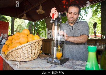 Fornitore spreme le arance per il succo di frutta per servire ai turisti. Efeso. Foto Stock