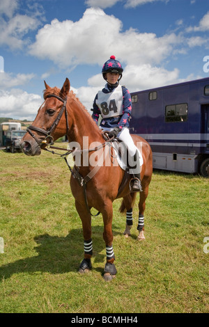 Ragazza seduta sul pony marrone a Pony club evento. Foto Stock