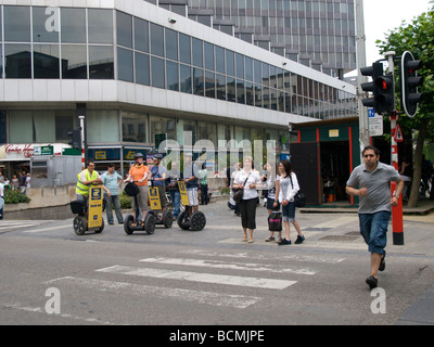 Gruppo di turisti su Segways e uomo che corre lungo la strada attraverso la luce rossa a Bruxelles Belgio Foto Stock