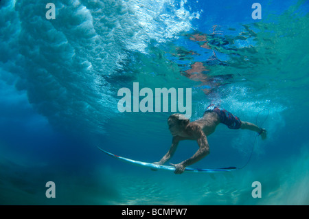 Surfer duck immersione sotto wave Foto Stock