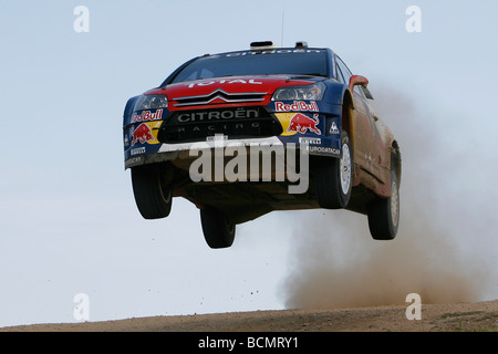 Sebastien Loeb e co-driver Daniel Elena conquista il cielo nel loro Citroen C4 WRC rally car sul 2009 Rallye di Sardegna. Foto Stock